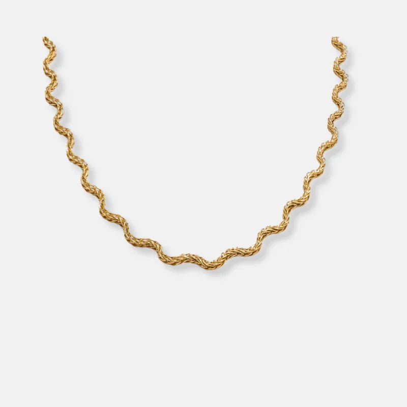 Gold chain necklace on a light gray background