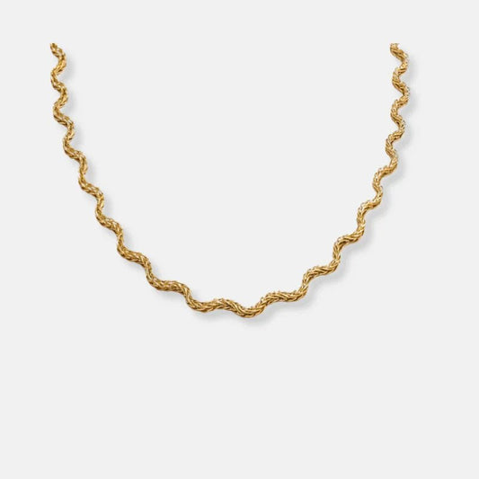 Gold chain necklace on a light gray background