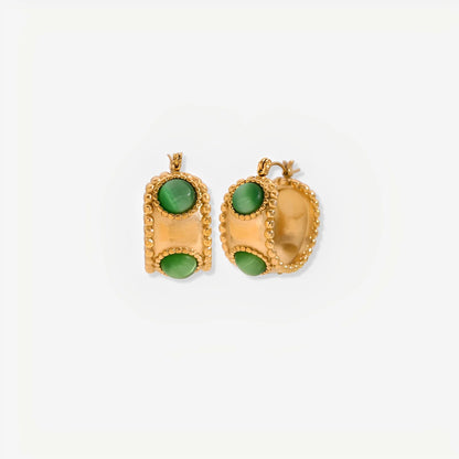 Gold earrings with green stones on a white background
