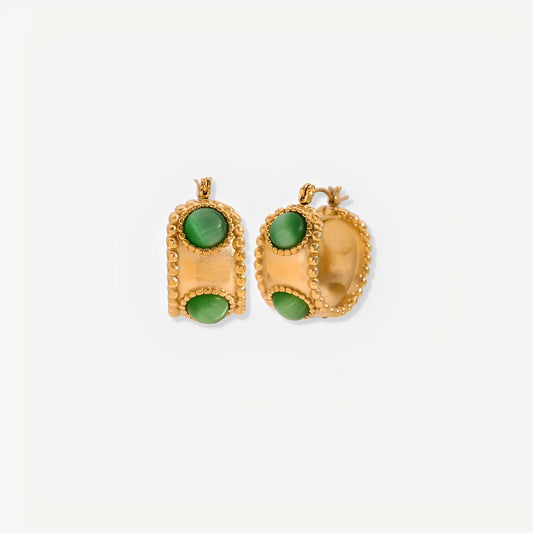Gold earrings with green stones on a white background