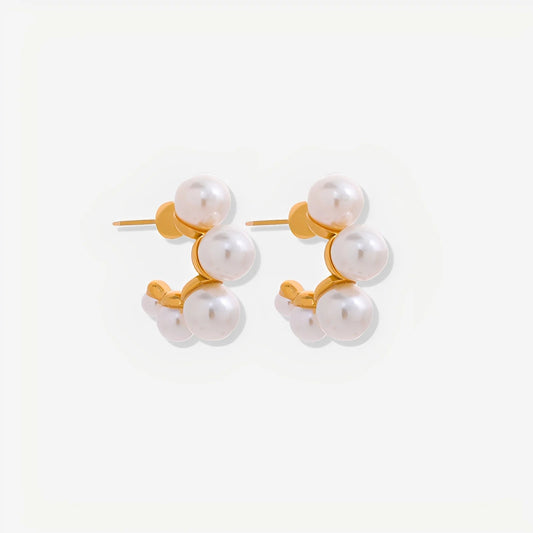 Pair of pearl earrings with gold accents on a white background