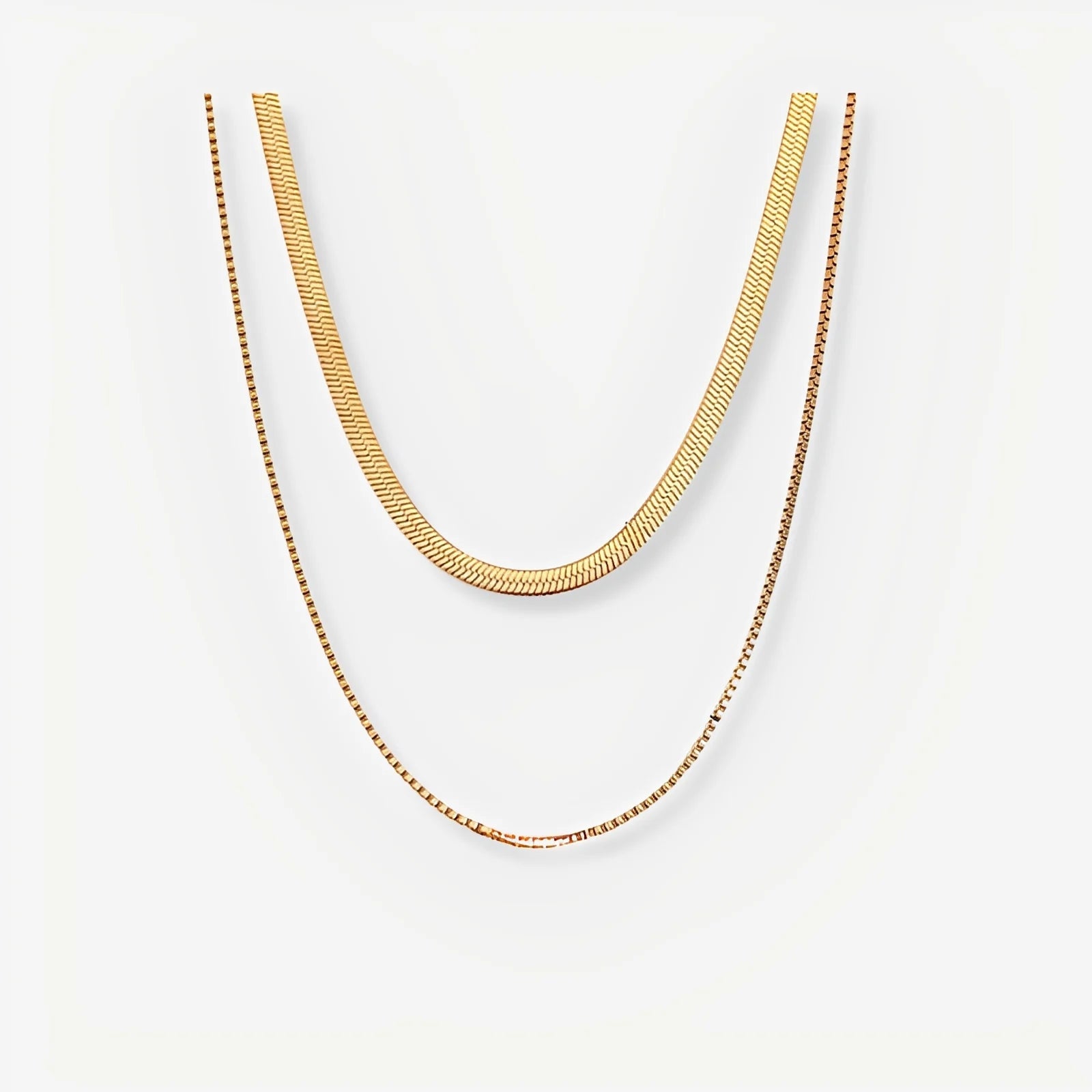 Two gold necklaces on a white background