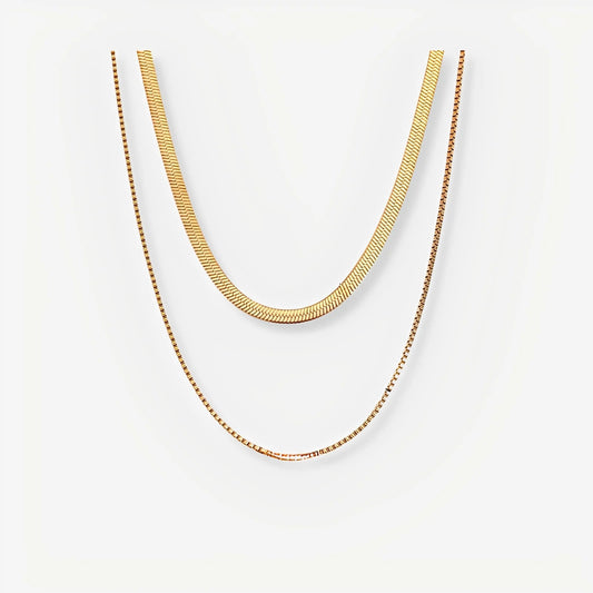 Two gold necklaces on a white background