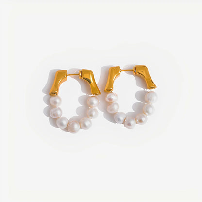 Gold hoop earrings with pearl-like beads on a white background