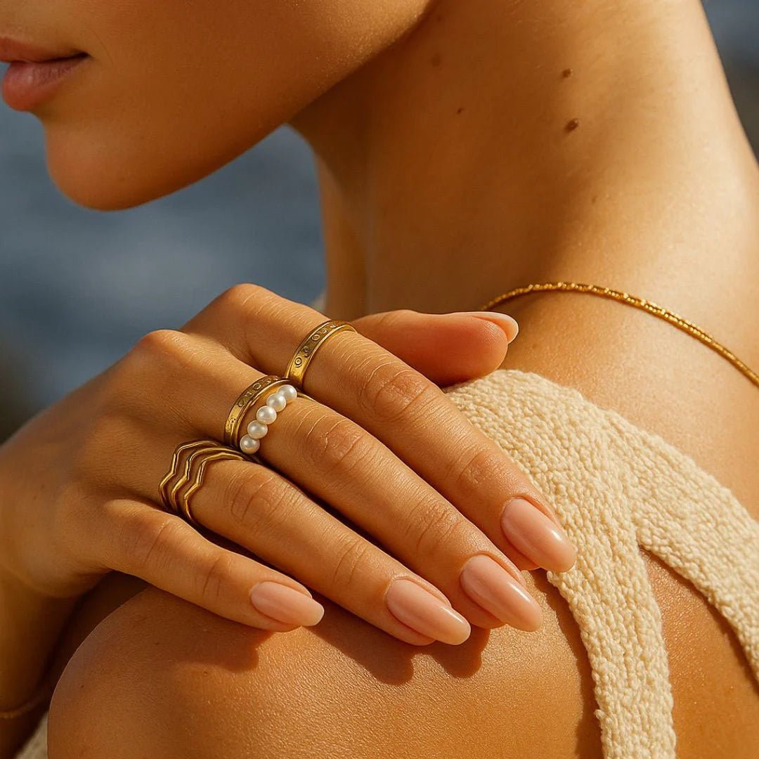 Close-up of a hand with gold rings on a blurred natural background