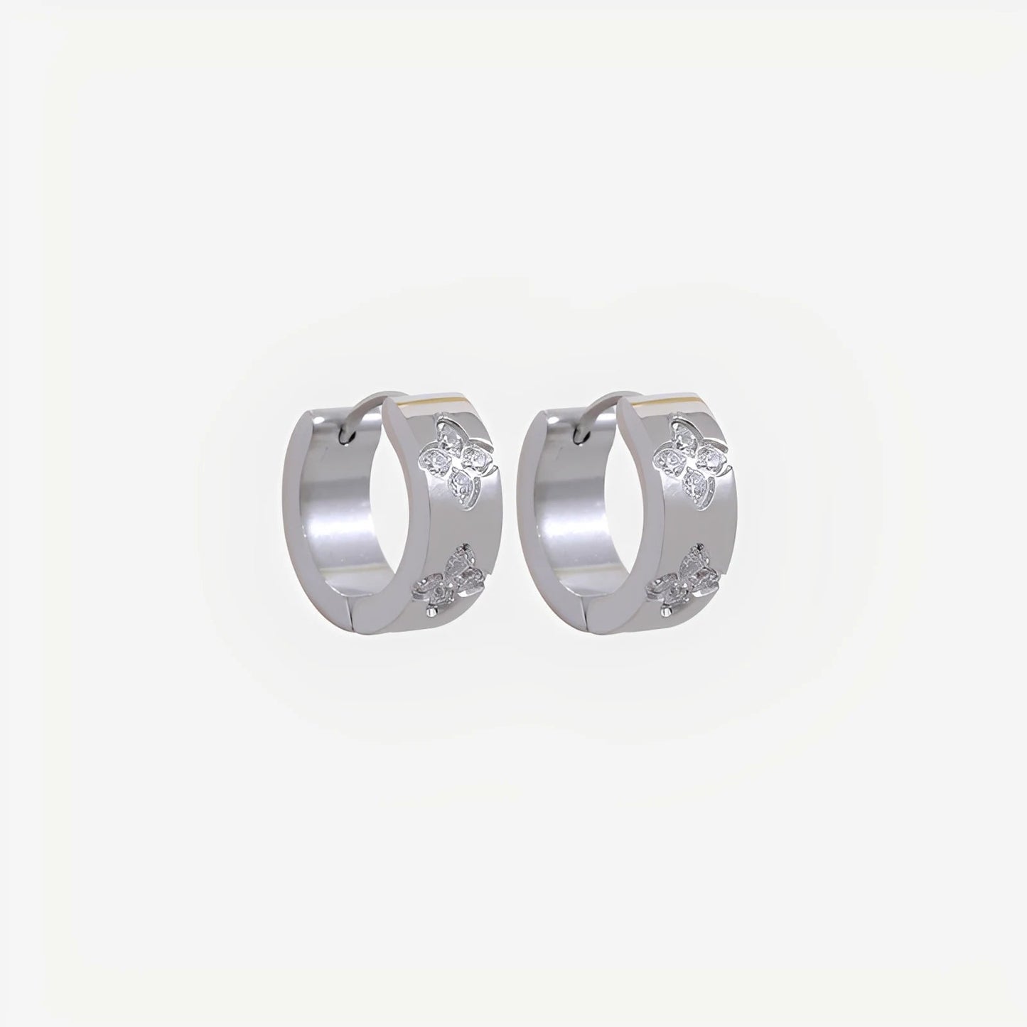 Silver hoop earrings with small round stones on a light gray background