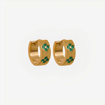 Gold hoop earrings with green gemstones on a light gray background
