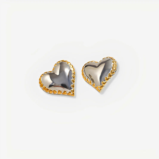 Heart-shaped earrings with gold and silver finish on a light gray background