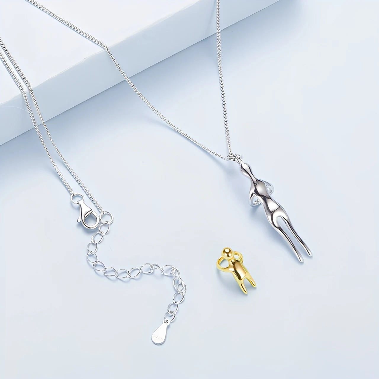 Two necklaces with unique pendants on a light blue background