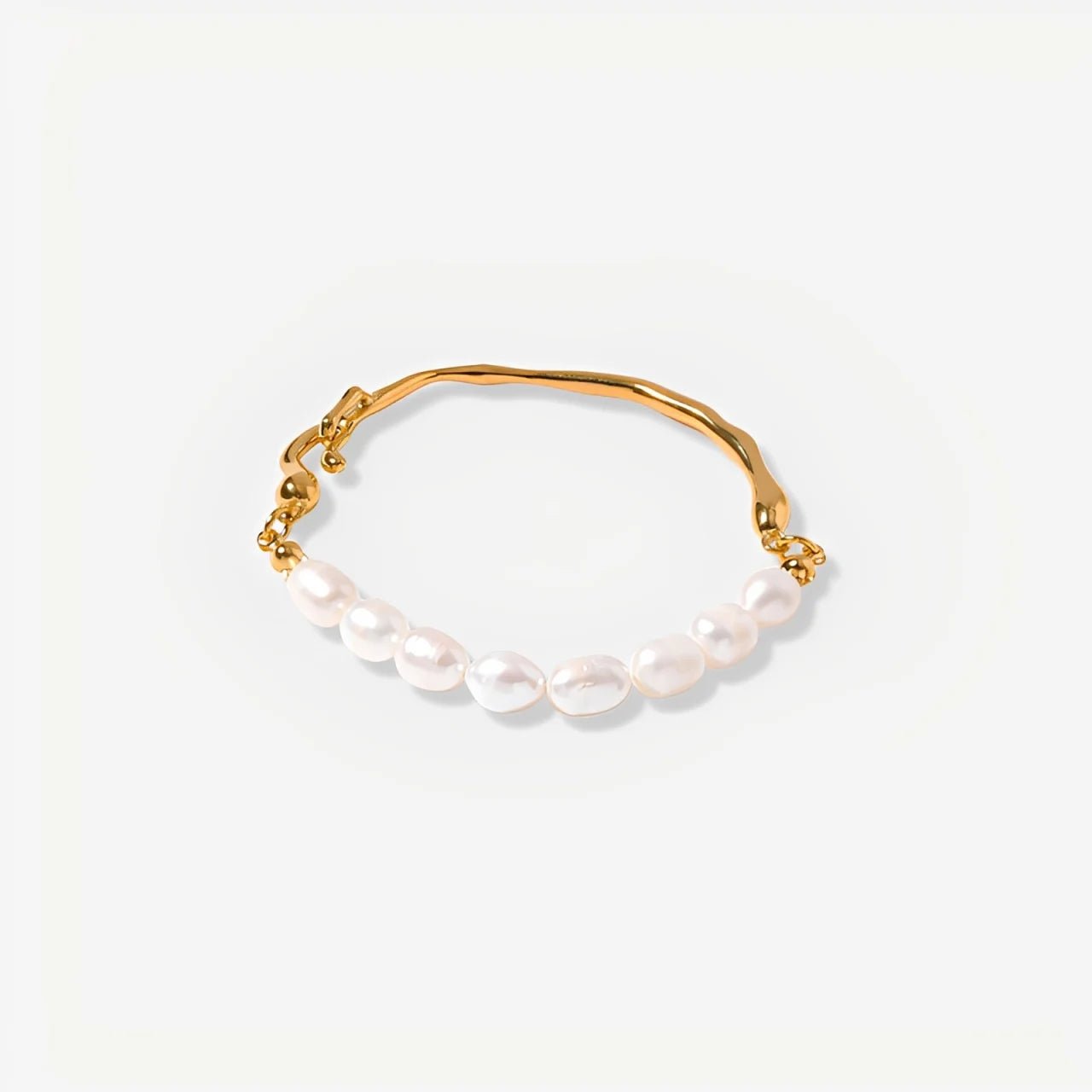Gold bracelet with pearls on a light gray background