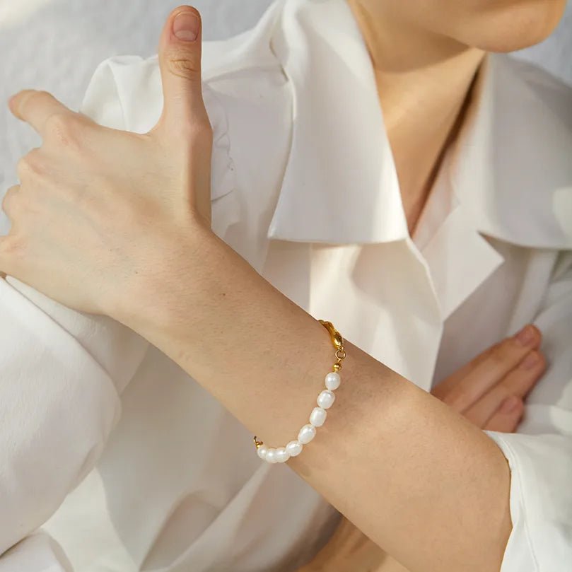 Person wearing a pearl bracelet on a white background