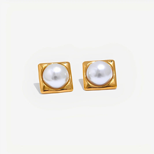 Pair of gold square-framed pearl earrings on a light gray background