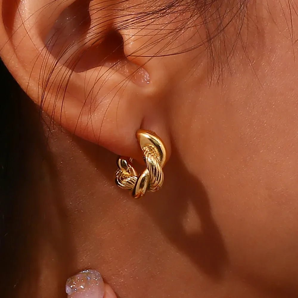 Close-up of a gold hoop earring on an ear with a blurred background