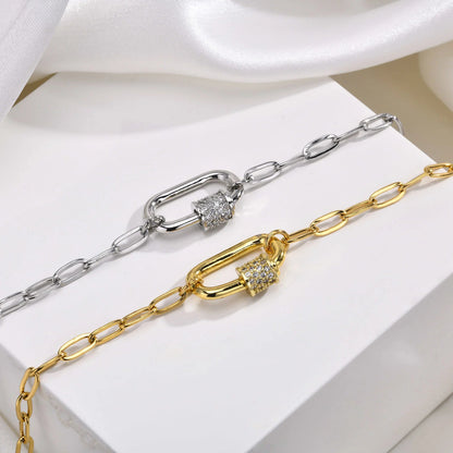 Gold and silver chain necklaces with diamond accents on a white fabric background