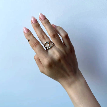 Hand wearing a silver ring with a blue gradient background