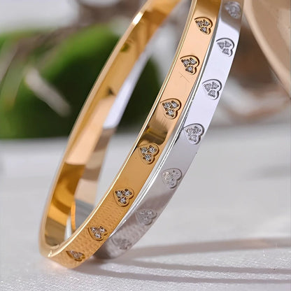 Gold and silver bangles with diamond-like embellishments on a light background