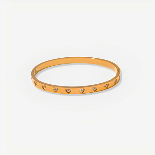 Gold bracelet with heart-shaped stones on a white background