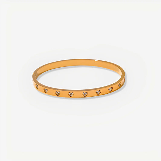 Gold bracelet with heart-shaped stones on a white background
