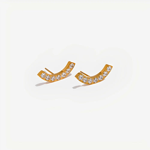 Gold earrings with clear stones on a light gray background