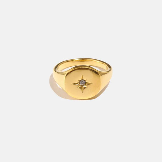 Gold ring with a star-shaped gemstone on a white background