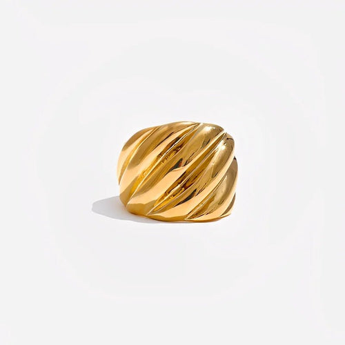 Gold ring with a ribbed texture on a light gray background