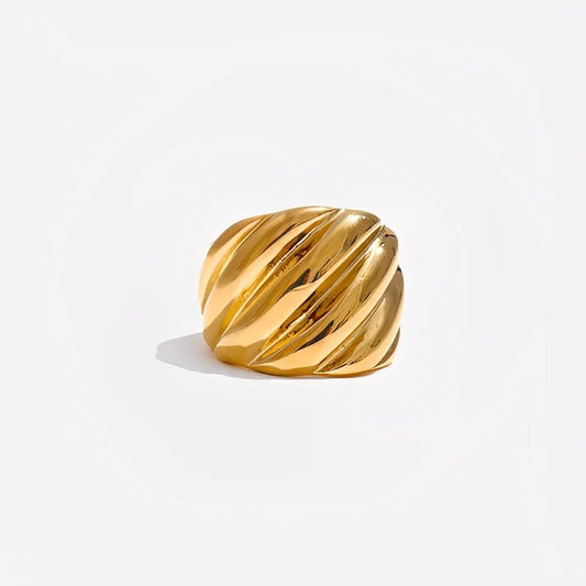 Gold ring with a ribbed texture on a light gray background