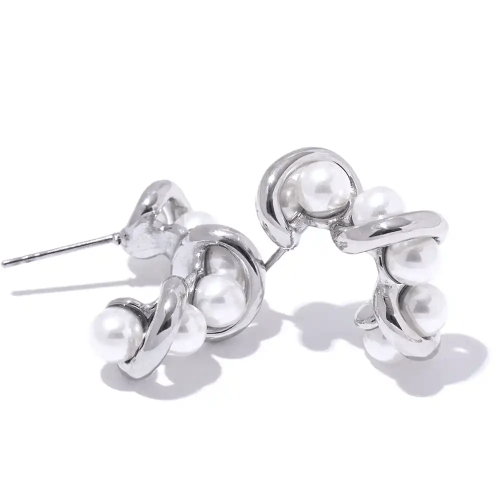 Silver earrings with pearls on a white background