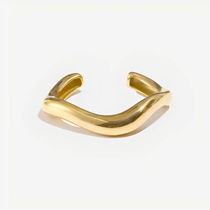 Gold bracelet on a light gray background