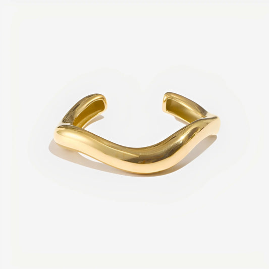 Gold bracelet on a light gray background