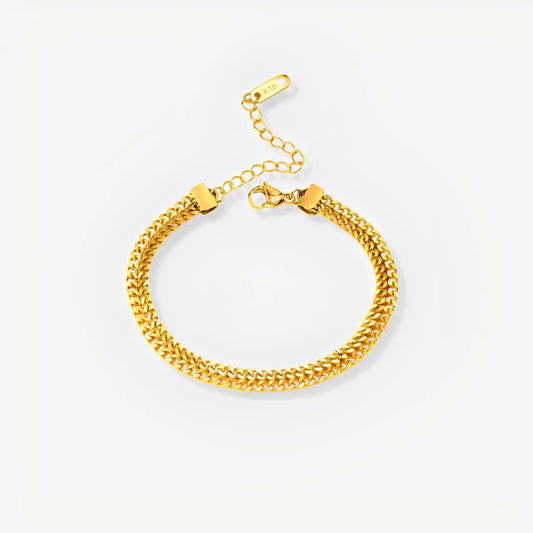 Gold chain bracelet on a light gray background