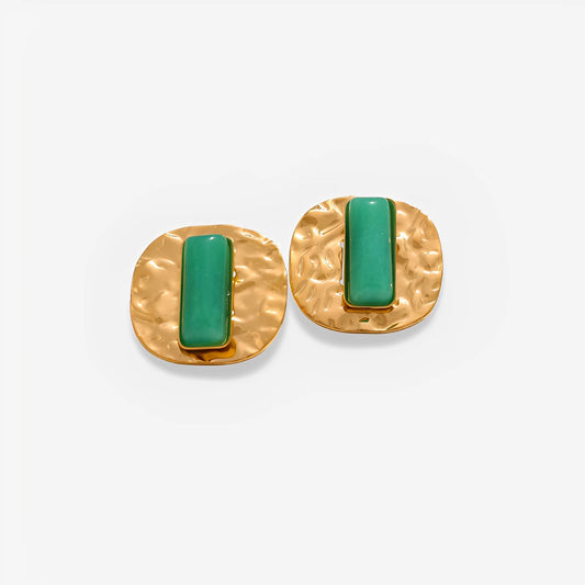 Gold earrings with green stones on a white background