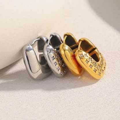 Three pairs of hoop earrings in gold, silver, and a combination of both on a light background.